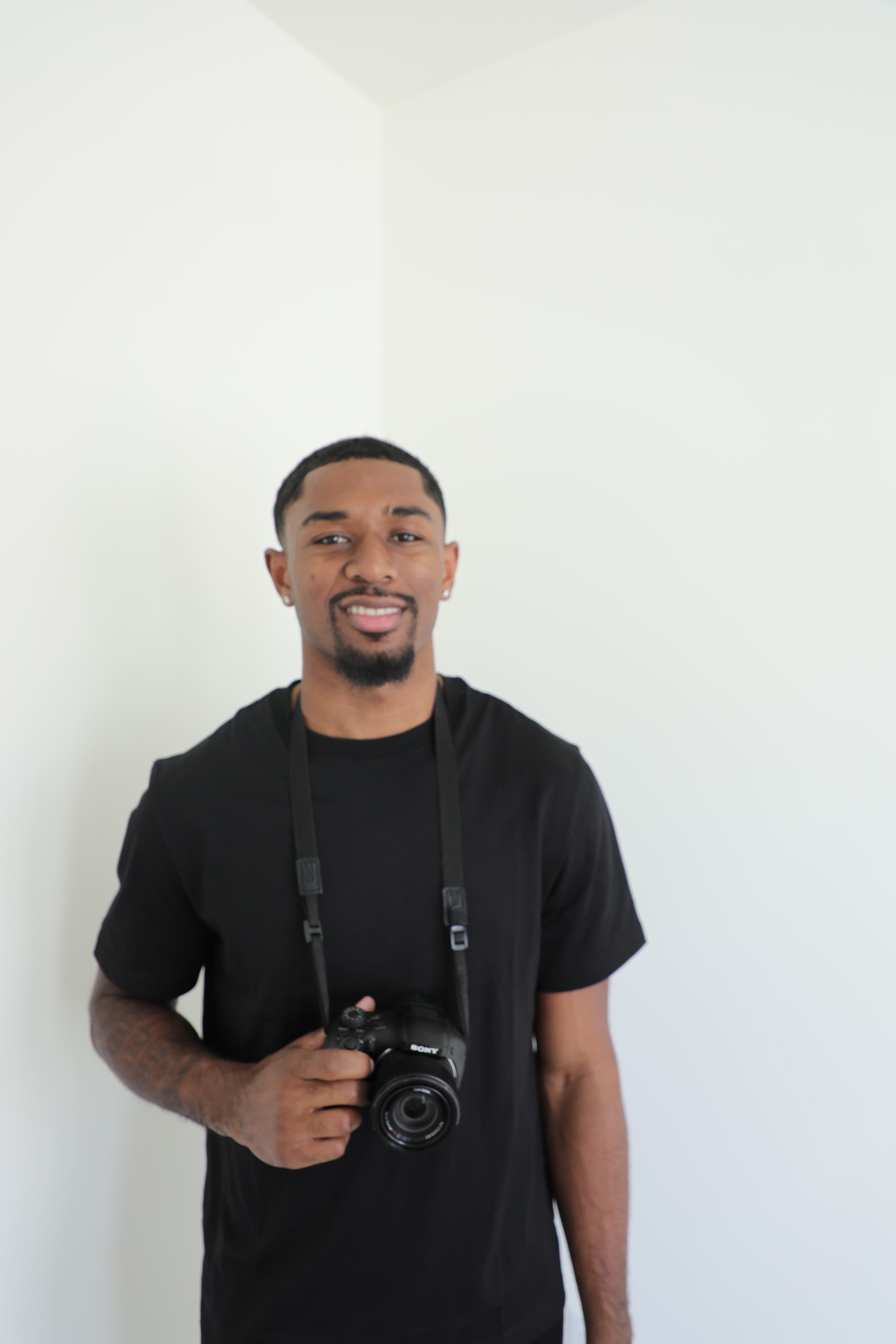 RJ Hart, photographer for HartTheFlix — smiling, holding a camera