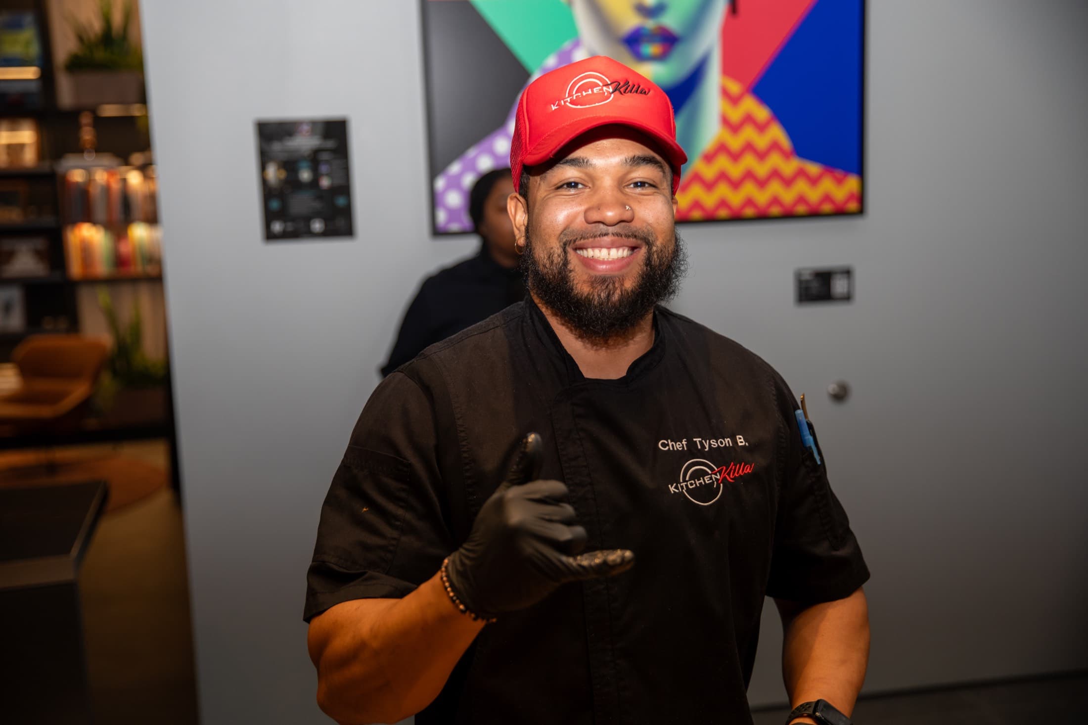 Chef in branded coat and cap, portrait with shaka gesture